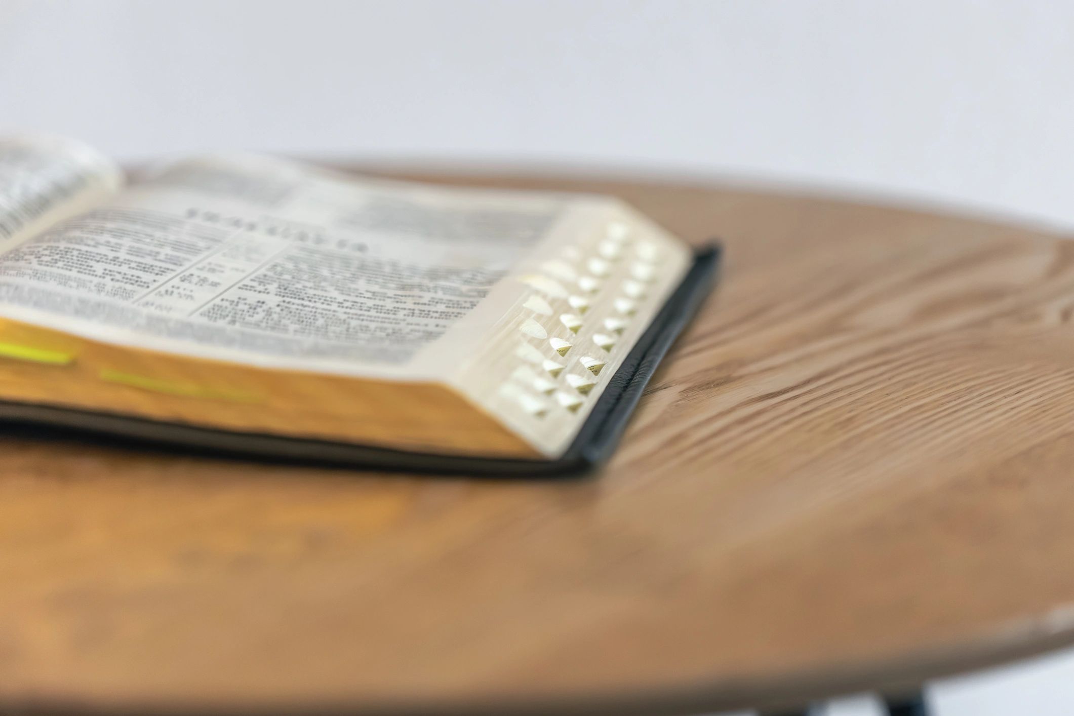 Open Bible with index tabs on a wooden table